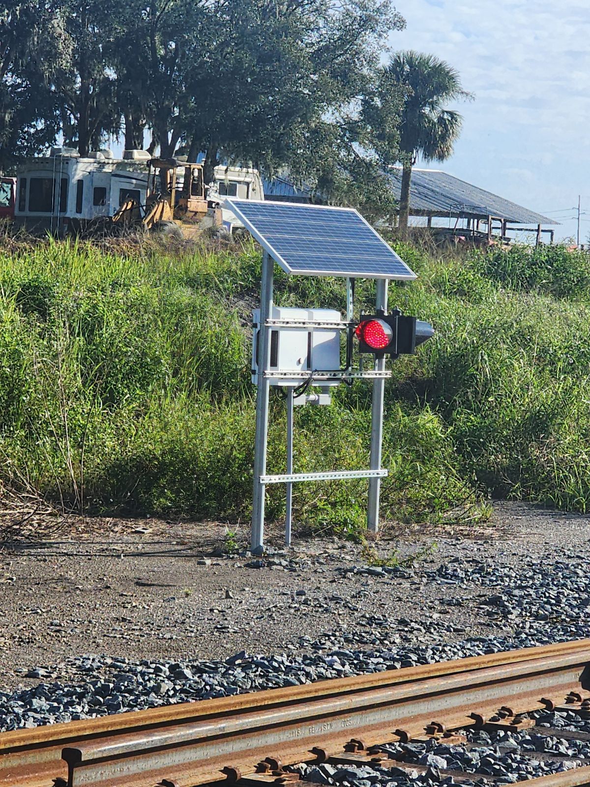 Solar-powered railroad switch position indicator installed beside railroad track